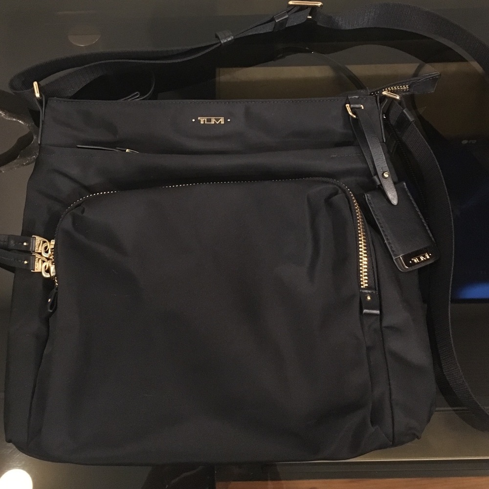 Tumi black crossover bag with gold zippers